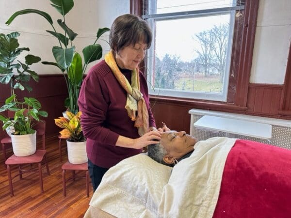 A woman is standing in front of a bed