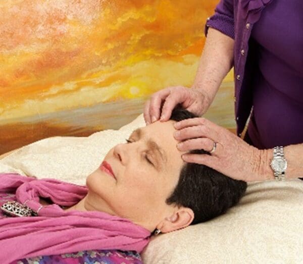 A woman is getting her head shaved by an esthetician.