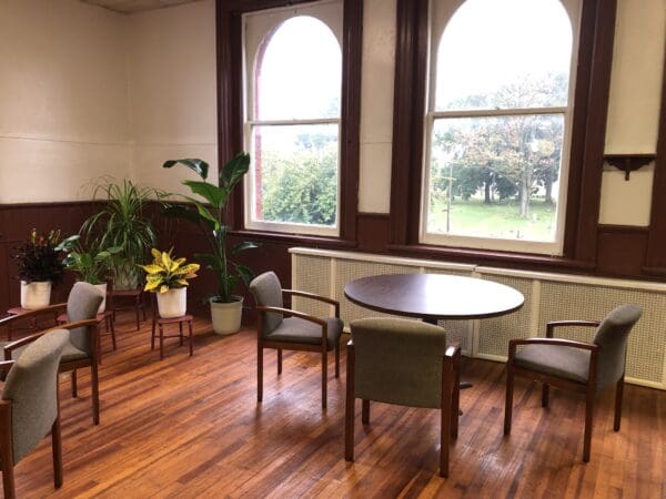 A room with four chairs and two tables.