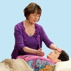 A woman is giving reiki to a child.