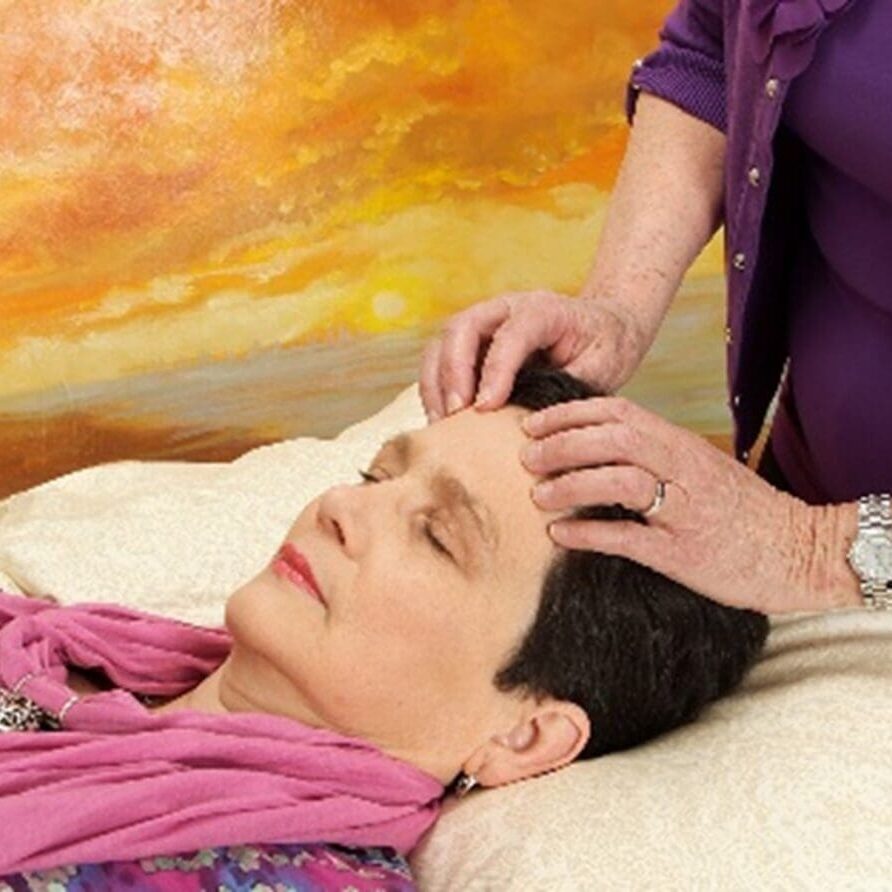 A woman is getting her head shaved by an esthetician.